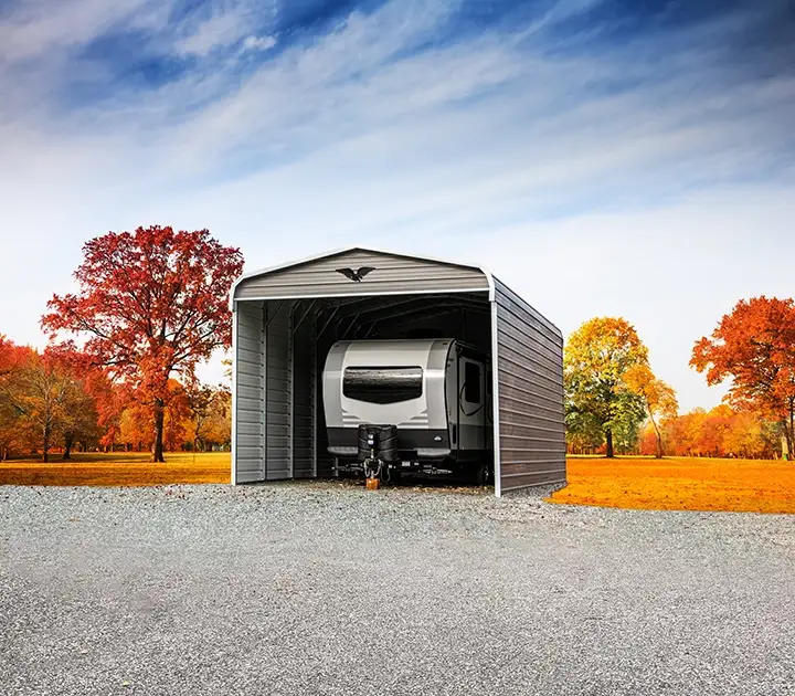 Fully enclosed building with boxed eave roof protecting a travel trailer from high wind and heavy snow